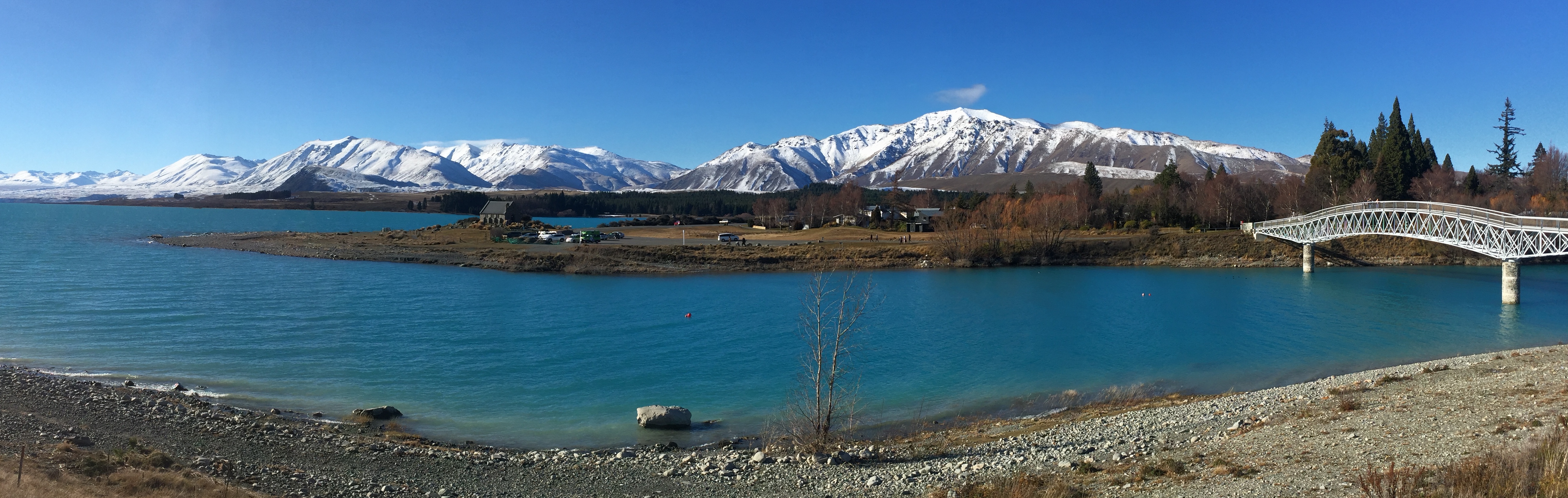 Blue-green lake water beneath distant snowy mountains
