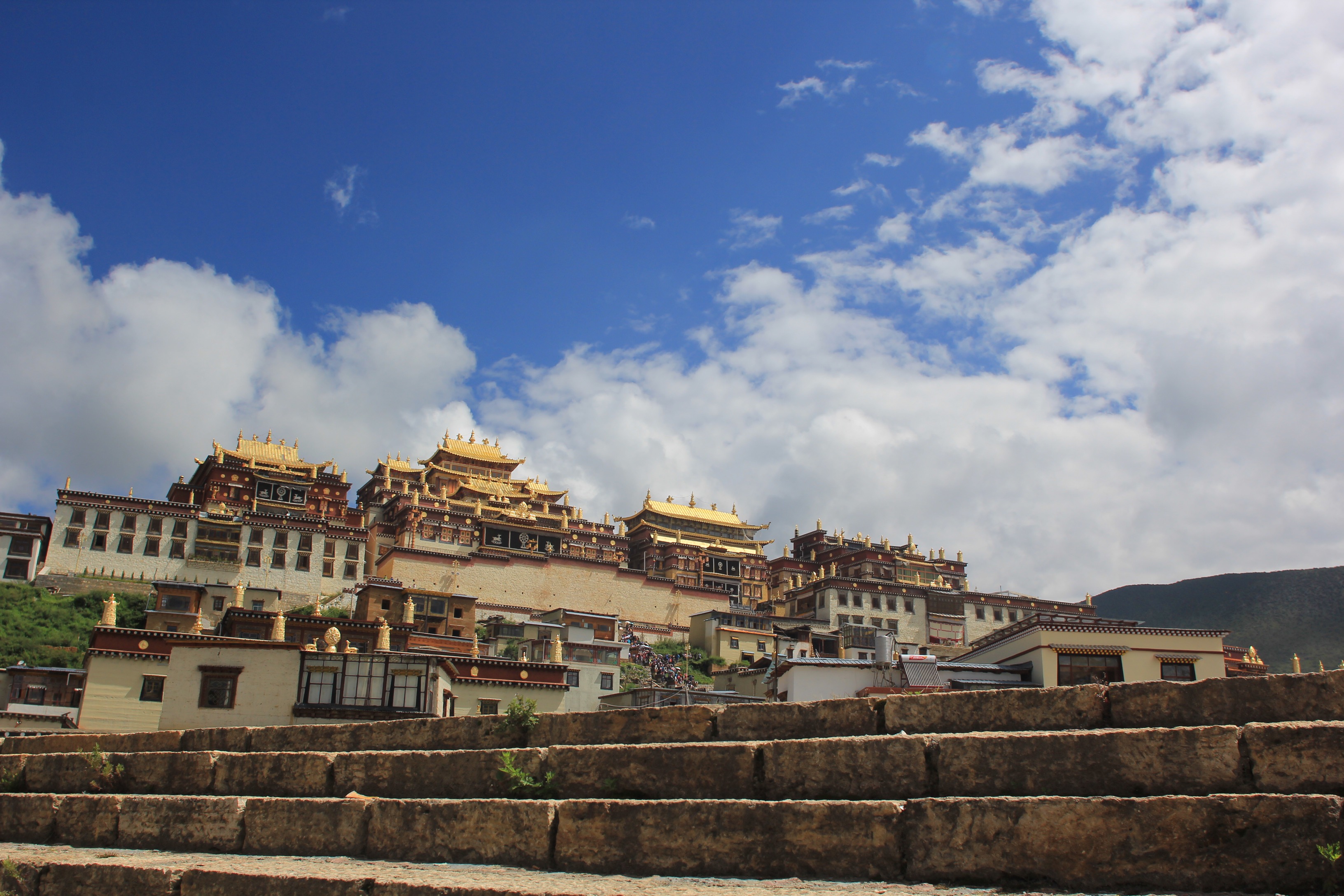 Golden-roofed temple buildings beneath a blue sky