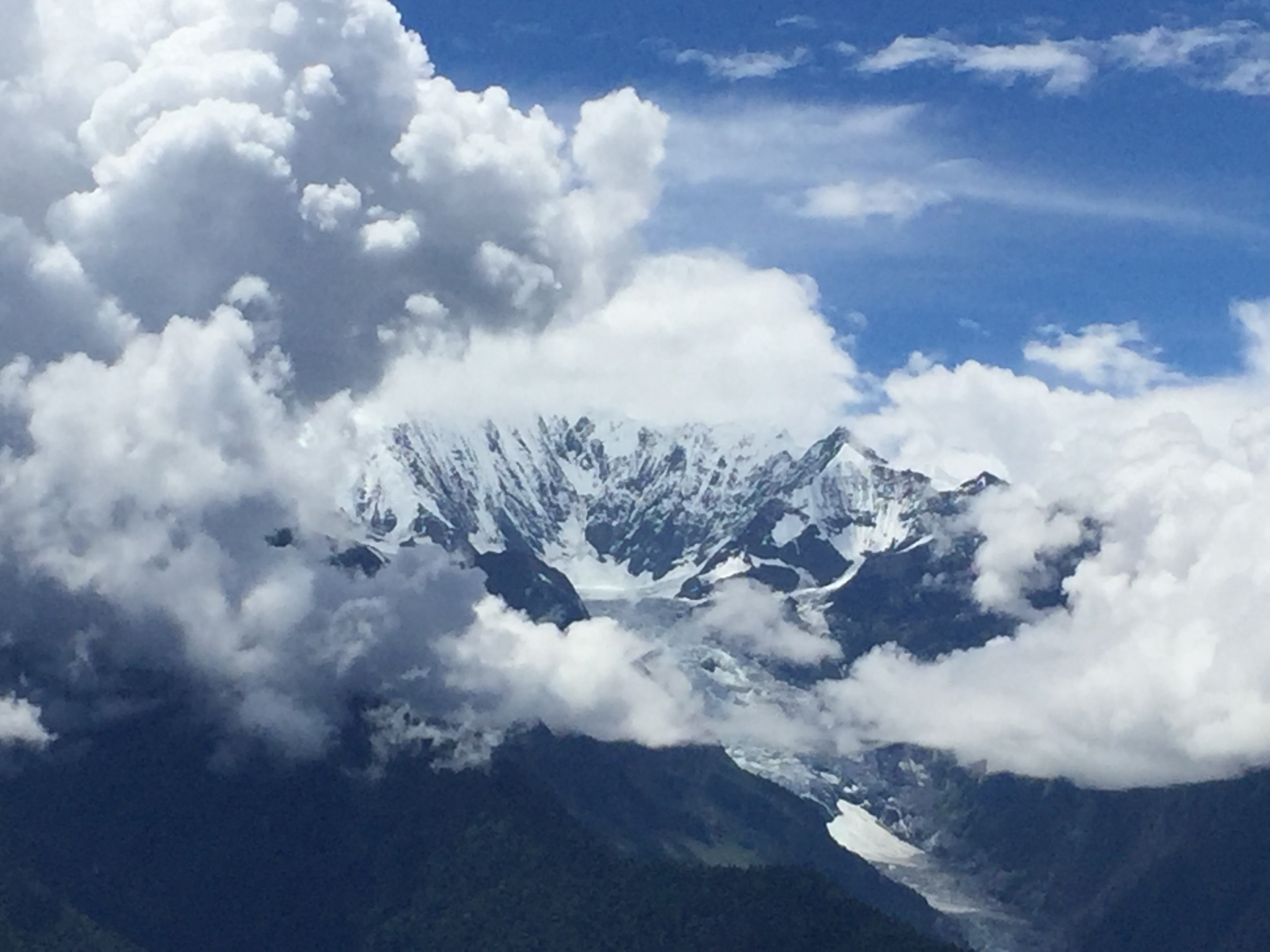Snowy peaks rising through white clouds