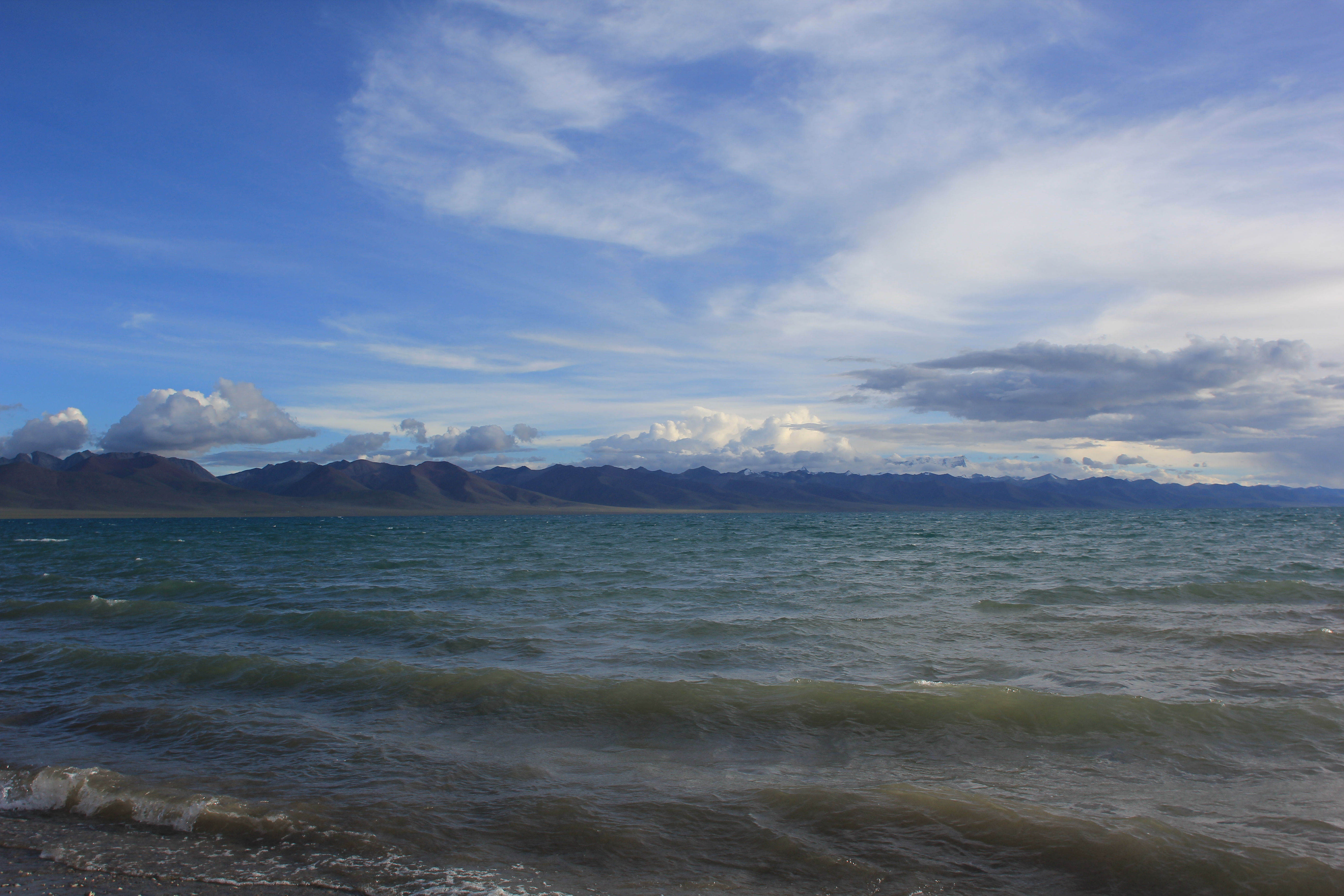 A lake and distant mountains beneath a blue sky