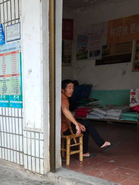 门口坐着的人与阳光照亮的墙面
