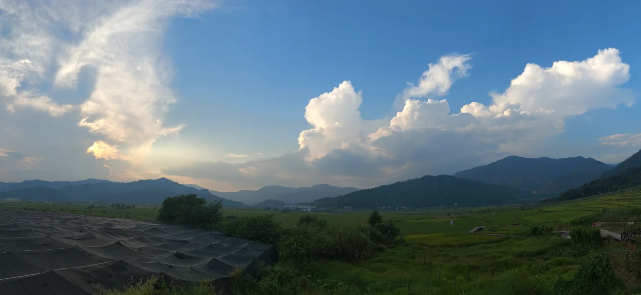 蓝天白云下连绵的绿色山脉