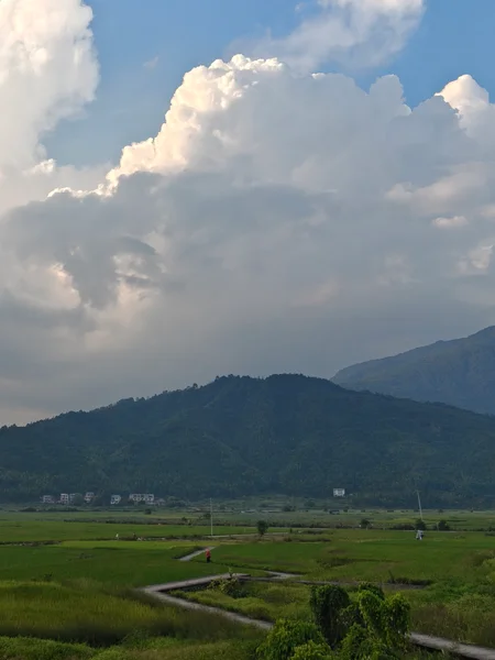 白云下的田野与山峦